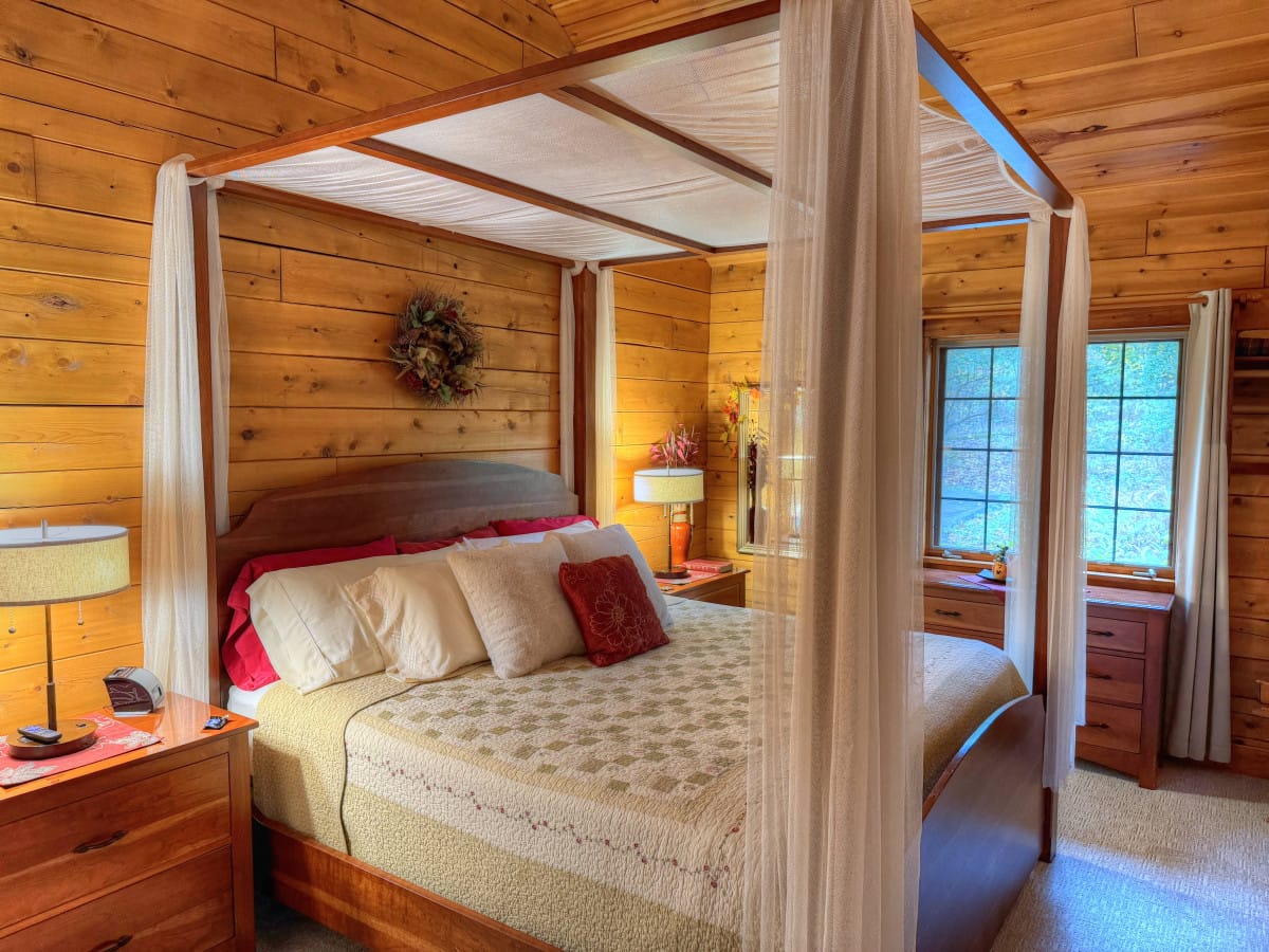 King four-poster bed with a sheer canopy inside Cherry Blossom Cabin at Ferngully Creek, Millersburg Ohio