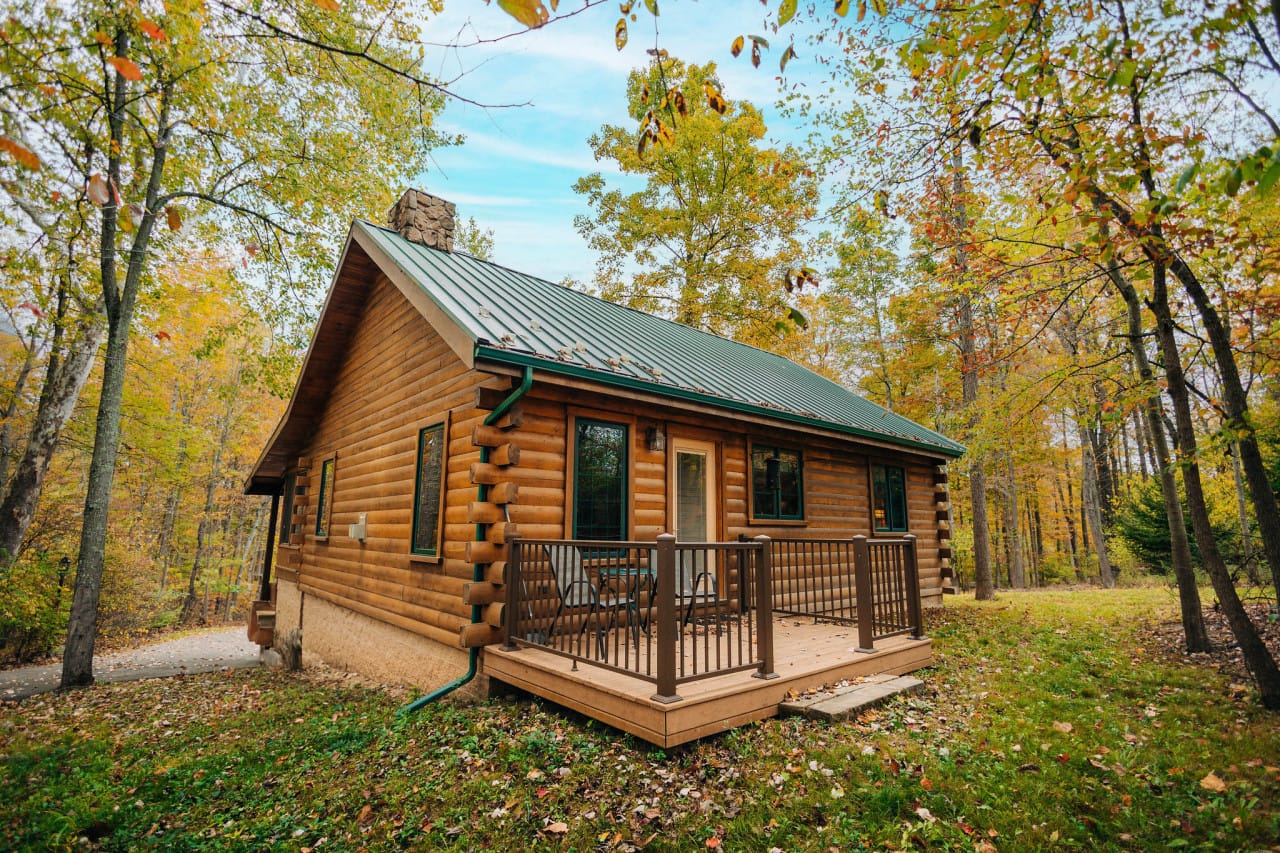 Rosewood Cabin, a log cabin with a green metal roof in the autumn woods at Ferngully Creek near Millersburg, Ohio