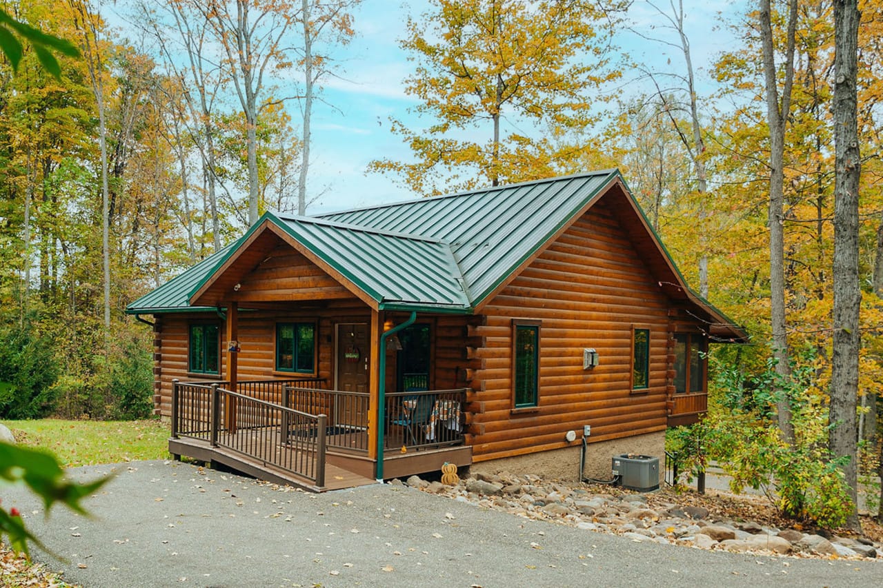 Sycamore Lane Cabin, a log cabin with a green metal roof among the trees at Ferngully Creek near Millersburg, Ohio
